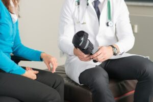 ortopedist shows leg brace to female patient